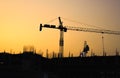 Silhouette of unfinished buildings and huge construction cranes