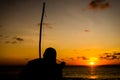 Silhouette of an unidentified person playing the Berimbau against the sunset