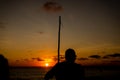 Silhouette of an unidentified person playing the Berimbau against the sunset