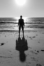 Silhouette of unknown man standing on beach black and white. Loneliness and solitude concept. Men silhouette on sea background.