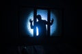 Silhouette of an unknown shadow figure on a door through a closed glass door. The silhouette of a human in front of a window at