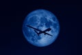 Silhouette of unmanned aerial vehicle UAV flying against background of huge full moon in dark starry space toned in trendy