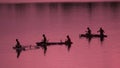 SILHOUETTE Unrecognizable local fishermen fishing in small boats at pink sunrise Royalty Free Stock Photo