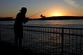 Silhouette of a person fishing at sunset from Port Hedland pier jetty