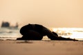 Silhouette Vacation of Asian woman relaxing in yoga Child`s Pose stretching exercises muscle for warm up on the beach Royalty Free Stock Photo