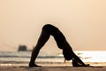 Silhouette Vacation of Asian woman relaxing in yoga Downward Facing dog or Adho Mukha Svanasana pose on sand and beach Royalty Free Stock Photo