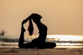 Silhouette Vacation of Asian woman relaxing in yoga king pigeon pose on the sand and beach with sunset beautiful sea in Tropical i Royalty Free Stock Photo