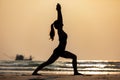 Silhouette Vacation of Asian woman relaxing in yoga Warrior one pose on the sand and beach with sunset beautiful sea in Tropical i Royalty Free Stock Photo