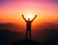 A silhouette of a victorious hiker standing on a mountain peak Royalty Free Stock Photo