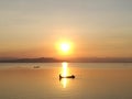 Silhouette view of beautiful sunset over the lake having boat in middle of sun reflection in summer