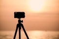 Silhouette of vintage camera on tripod shooting beautiful calm sea