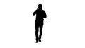 Silhouette Walking man is talking on the phone and smiling. Royalty Free Stock Photo