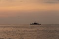 Silhouette of a warship sails along the trade route to protect national resources from illegal activities at sea