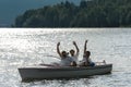 Waving men sitting in motorboat back lit Royalty Free Stock Photo