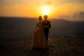 silhouette of wedding Couple statue holding hand together during sunset with evening sky background. Wedding concept. Royalty Free Stock Photo