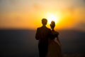 silhouette of wedding Couple statue holding hand together during sunset with evening sky background. Wedding concept. Royalty Free Stock Photo