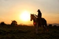 Silhouette of western riders against amber colored sunset Royalty Free Stock Photo
