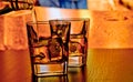 Silhouette of whiskey glasses with ice on bar table on warm atmosphere Royalty Free Stock Photo