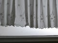 Silhouette white Lace satin curtain hanging on window above window jamp with sunlight semitransparent behind, decoration interior Royalty Free Stock Photo