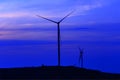 Silhouette wind turbine farm over moutain with twilight sky and Royalty Free Stock Photo