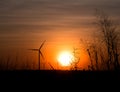 Silhouette wind turbine and grass field with twilight