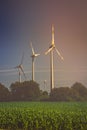 Silhouette of wind turbines on the fields in the light of the rising sun