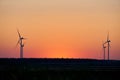 Silhouette Of Wind Turbines At Sunset. The Concept Of Alternative Energy