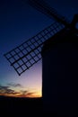 Silhouette of a windmill at dusk with the last lights of the sun on the horizon. Consuegra. Royalty Free Stock Photo