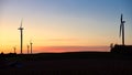 Silhouette of windmills in against the sunset.