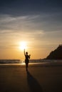 Silhouette of woman against the background of the sunset sky on the ocean. Pose of girl touching the sun Royalty Free Stock Photo
