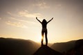 Silhouette of a woman with arms outstretched at sunrise