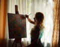 Silhouette woman artist drawing paint picture on easel indoors Royalty Free Stock Photo