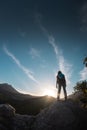 The silhouette of a woman with a backpack against the backdrop of a mountain at sunset Royalty Free Stock Photo