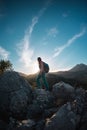 The silhouette of a woman with a backpack against the backdrop of a mountain at sunset Royalty Free Stock Photo