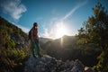 The silhouette of a woman with a backpack against the backdrop of a mountain at sunset Royalty Free Stock Photo