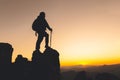 Silhouette woman backpacking travel atop a high rock, sports and active life concept, success