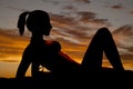 Silhouette of a woman in a bikini on elbows let up Royalty Free Stock Photo