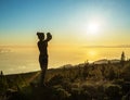 Silhouette of woman with camera. Woman takes photo of La Gomera Island in the rays of the setting sun. Tenerife Island Royalty Free Stock Photo