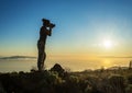 Silhouette of woman with camera. Woman takes photo of La Gomera Island in the rays of the setting sun. Tenerife Island Royalty Free Stock Photo