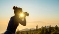 Silhouette of woman with camera. Woman takes photo of La Gomera Island in the rays of the setting sun. Tenerife Island Royalty Free Stock Photo