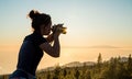 Silhouette of woman with camera. Woman takes photo of La Gomera Island in the rays of the setting sun. Tenerife Island Royalty Free Stock Photo