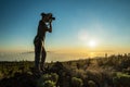 Silhouette of woman with camera. Woman takes photo of La Gomera Island in the rays of the setting sun. Tenerife Island Royalty Free Stock Photo