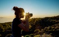 Silhouette of woman with camera. Woman takes photo of La Gomera Island in the rays of the setting sun. Tenerife Island Royalty Free Stock Photo