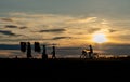 Silhouette of woman carry pack of rice and walk along the road near water reservoir follow by little children walk and other ride Royalty Free Stock Photo