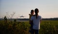 Silhouette of woman with child looking at landing commercial airplane Royalty Free Stock Photo