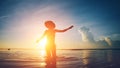 Silhouette of woman dancing in the ocean at sunset with hat Royalty Free Stock Photo