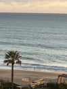 Silhouette of woman in distance along beach at sea