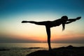 Silhouette of a woman doing yoga exercises on the ocean beach Royalty Free Stock Photo