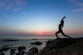 Silhouette of woman doing yoga exercises on ocean beach Royalty Free Stock Photo