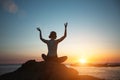 Silhouette of a woman doing yoga on the sea beach during a beautiful sunset. Royalty Free Stock Photo